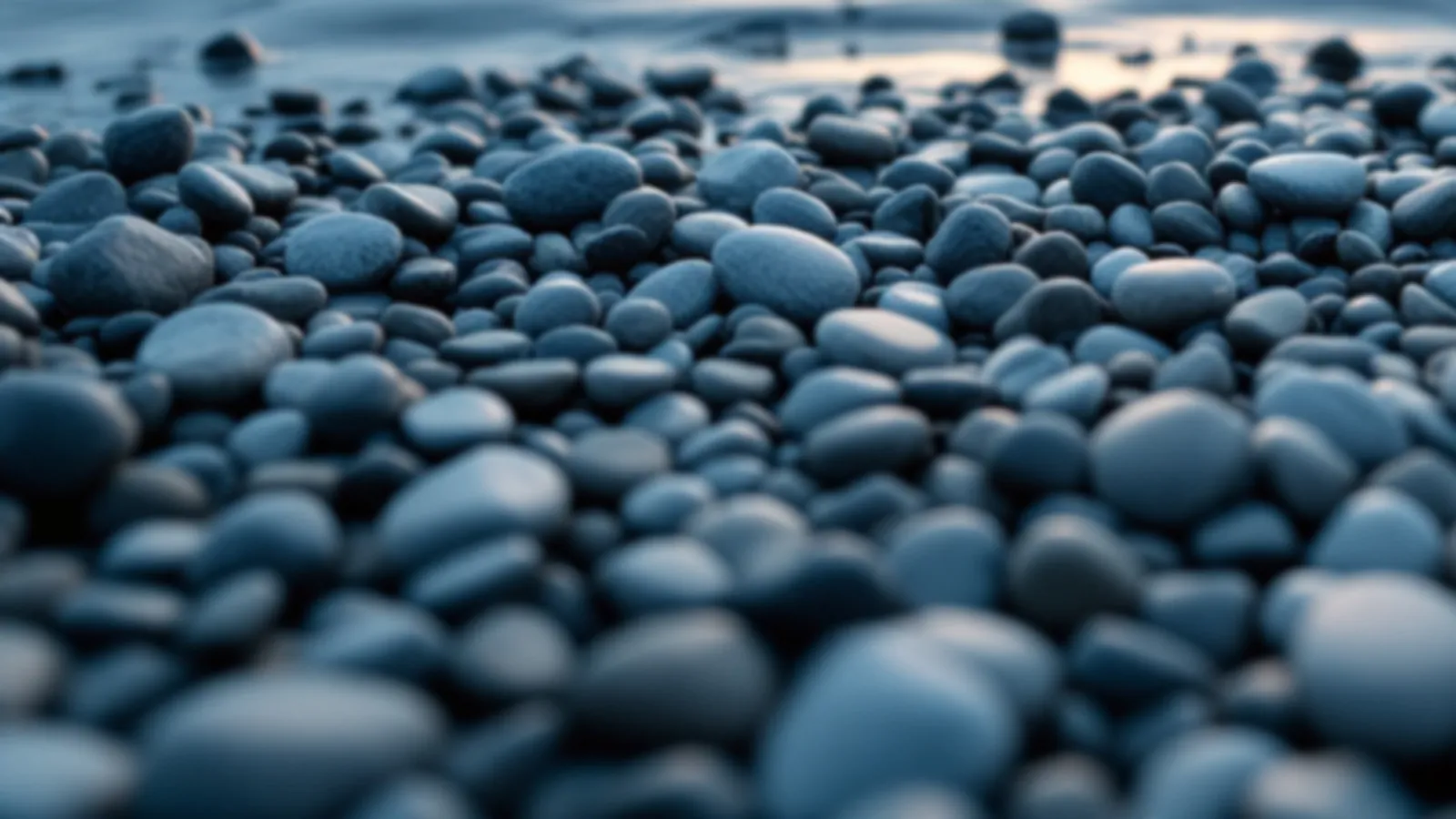 Smooth grey pebbles on a calm lake shore with gentle ripples at dawn, the FundsPebble view of cash loans online, $100 – $5,000
